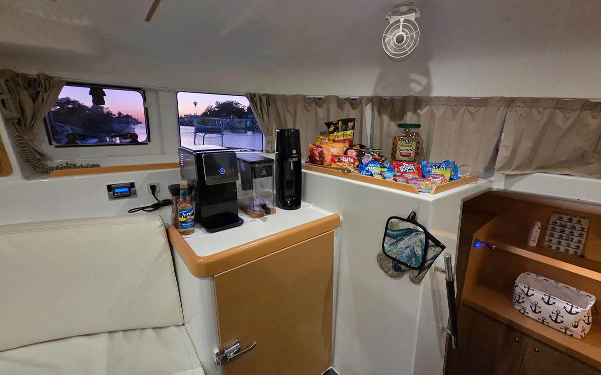 Coffee maker and snacks on the counter in Majik’s salon, the water outside the windows